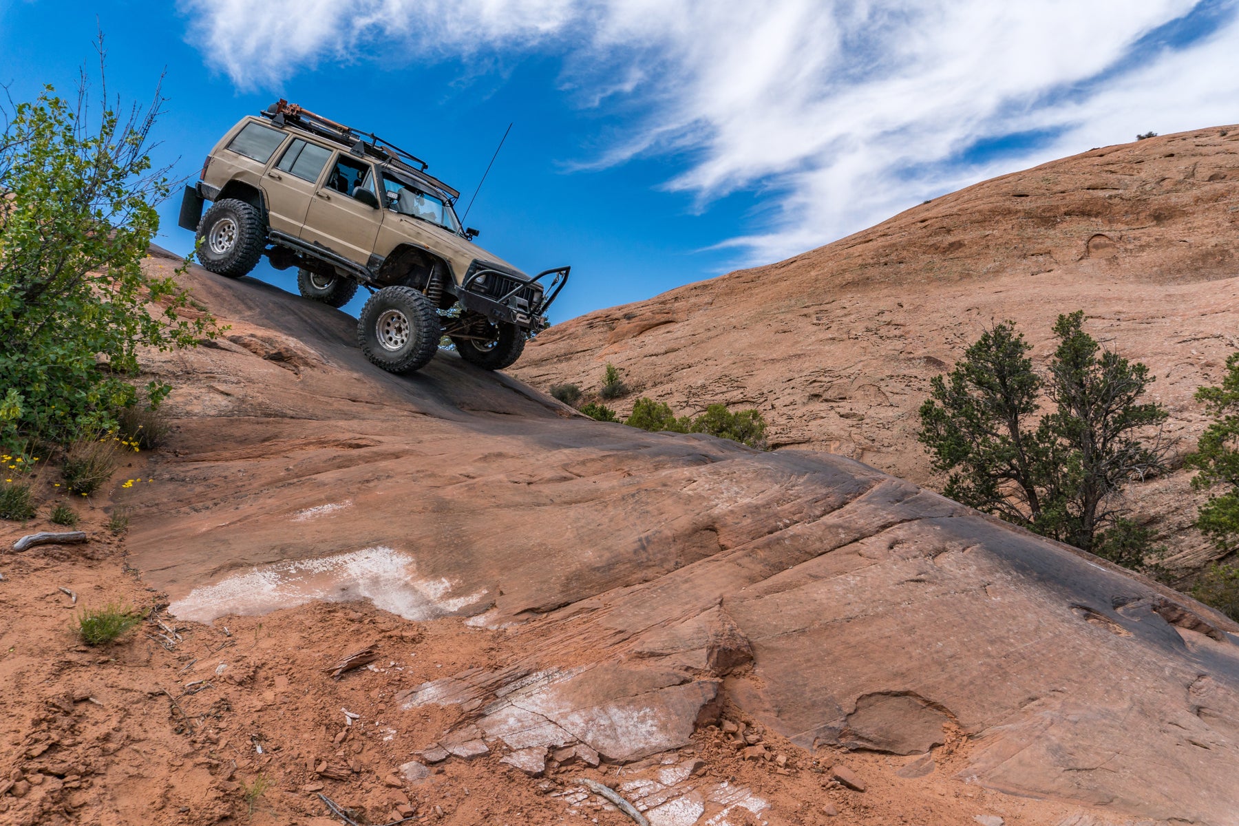 outdoor photo of an SUV driving down a hill.